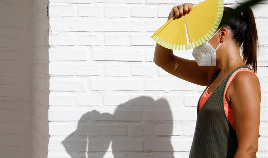 Una mujer se protege del sol con un abanico en Córdoba (EFE).
